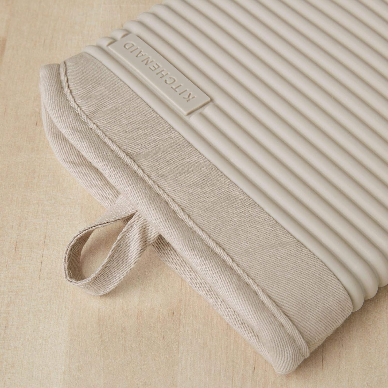 KitchenAid ribbed soft silicone oven mitt 2-pack set in Milkshake Tan, measuring 7.5 x 13 inches.
